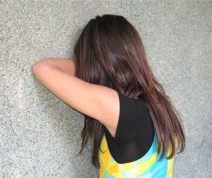 woman leaning against a wall crying