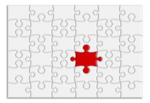 white jigsaw with one red piece