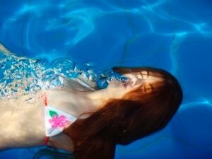 woman exhaling in swimming pool