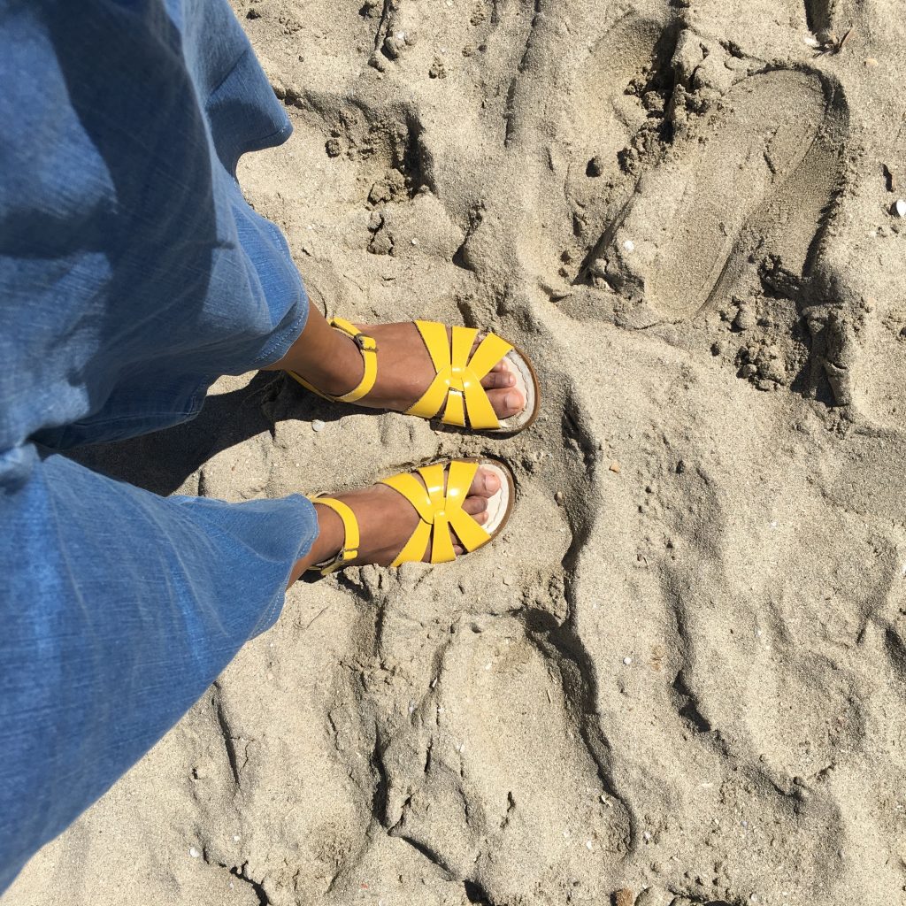 Nat Baggage Reclaim feet in sand
