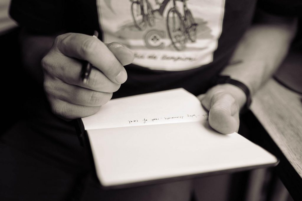 On giving and receiving. Person making notes in their notebook. Photo by Calum MacAulay on Unsplash