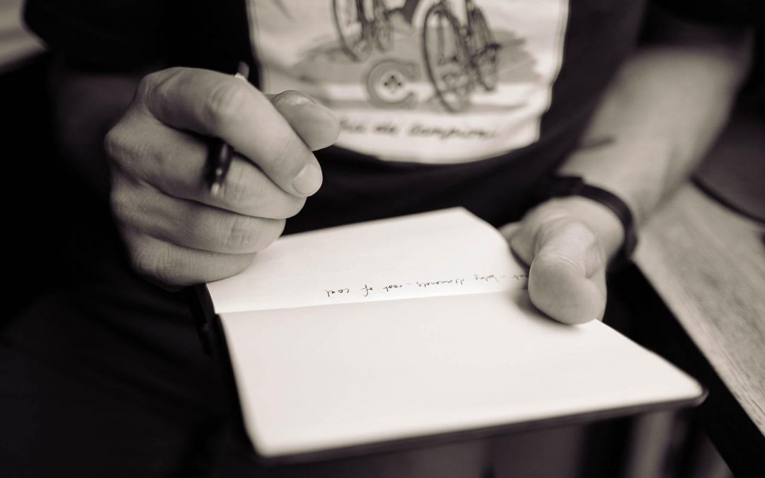Person making notes in their notebook. Photo by Calum MacAulay on Unsplash